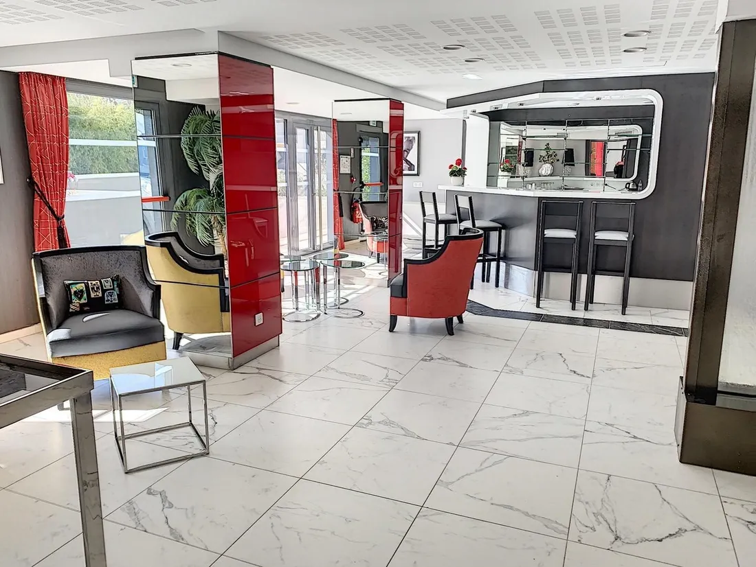 Salon-bar d'une résidence OBEO avec fauteuils et comptoir