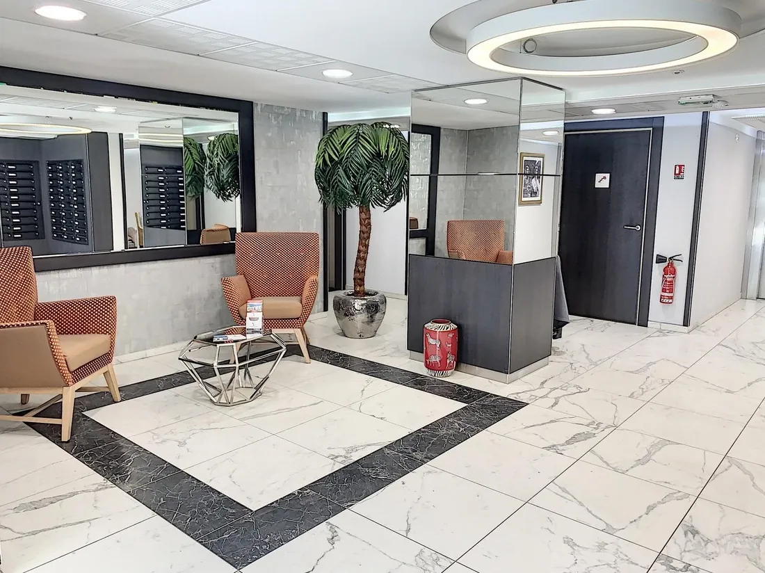 Hall d'accueil élégant d'une résidence OBEO avec fauteuils et sol en marbre