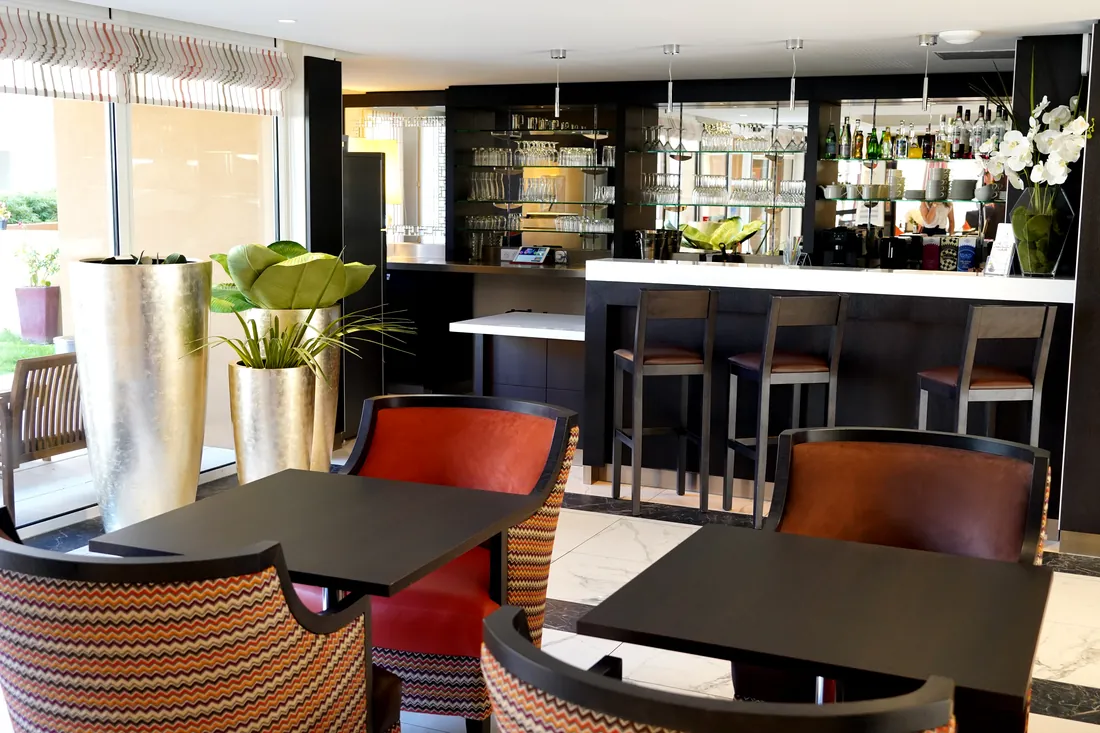 Bar et salon commun d'une résidence OBEO avec comptoir et fauteuils