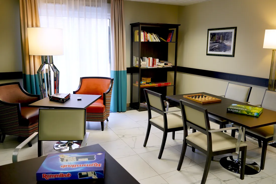 Salon commun d'une résidence OBEO avec bibliothèque et jeux de société