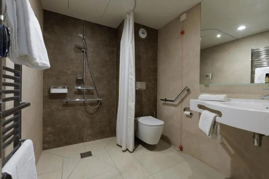 Salle de bain adaptée : douche de plain-pied, barres d’appui et sèche-serviettes
