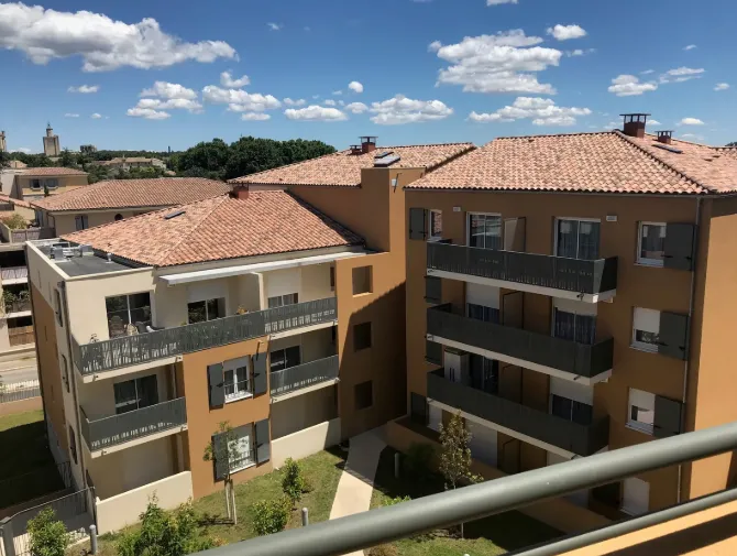 Une résidence seniors du sud de la France, ses toits de tuiles et ses balcons dominant la vieille ville
