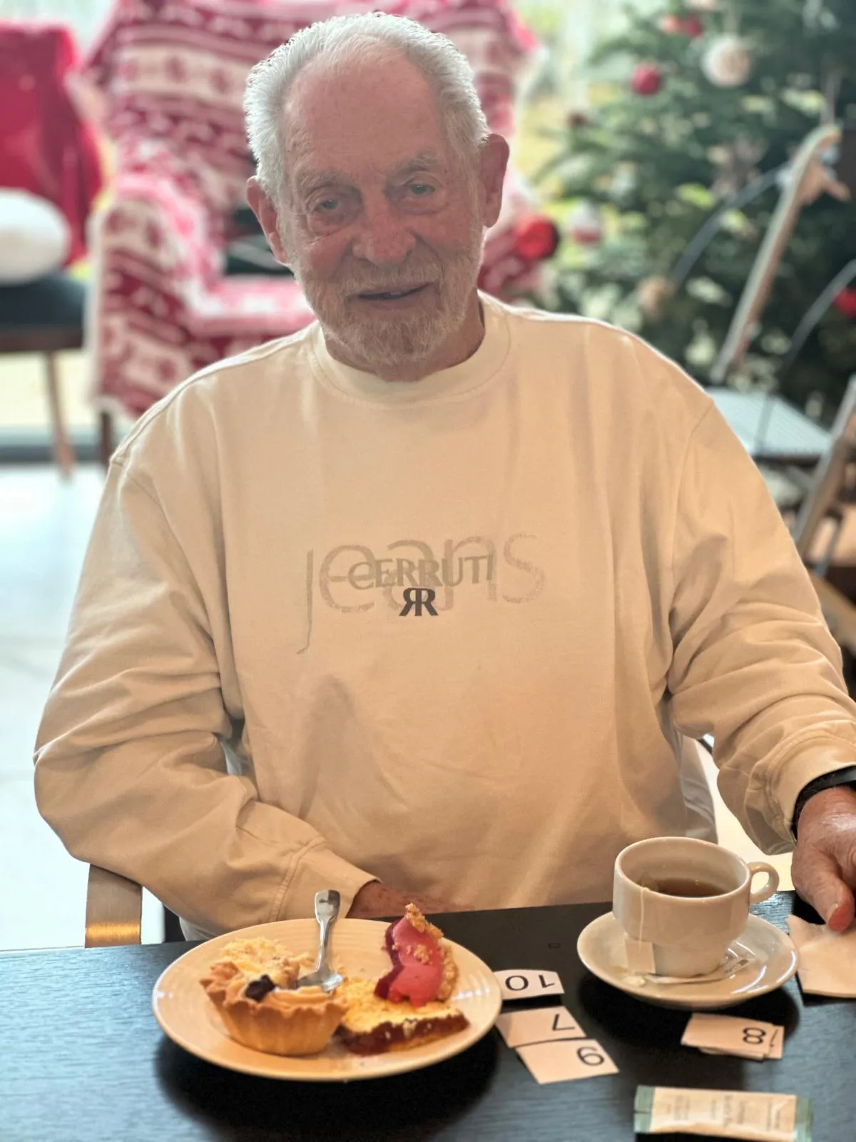 Un résident sourit devant sa part de gâteau et sa tasse de café