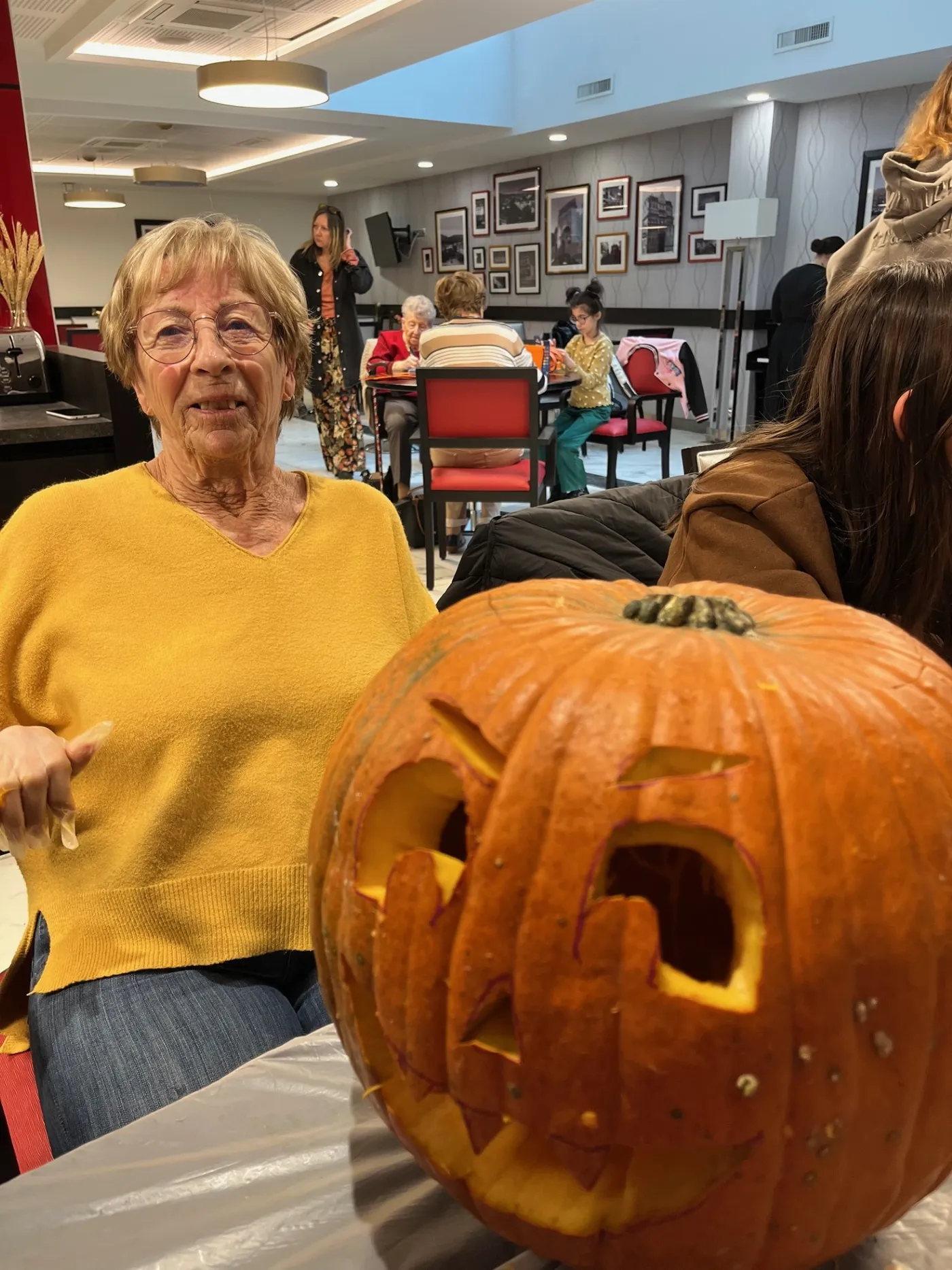 Une résidente assise à côté de la citrouille qu'elle vient de sculpter