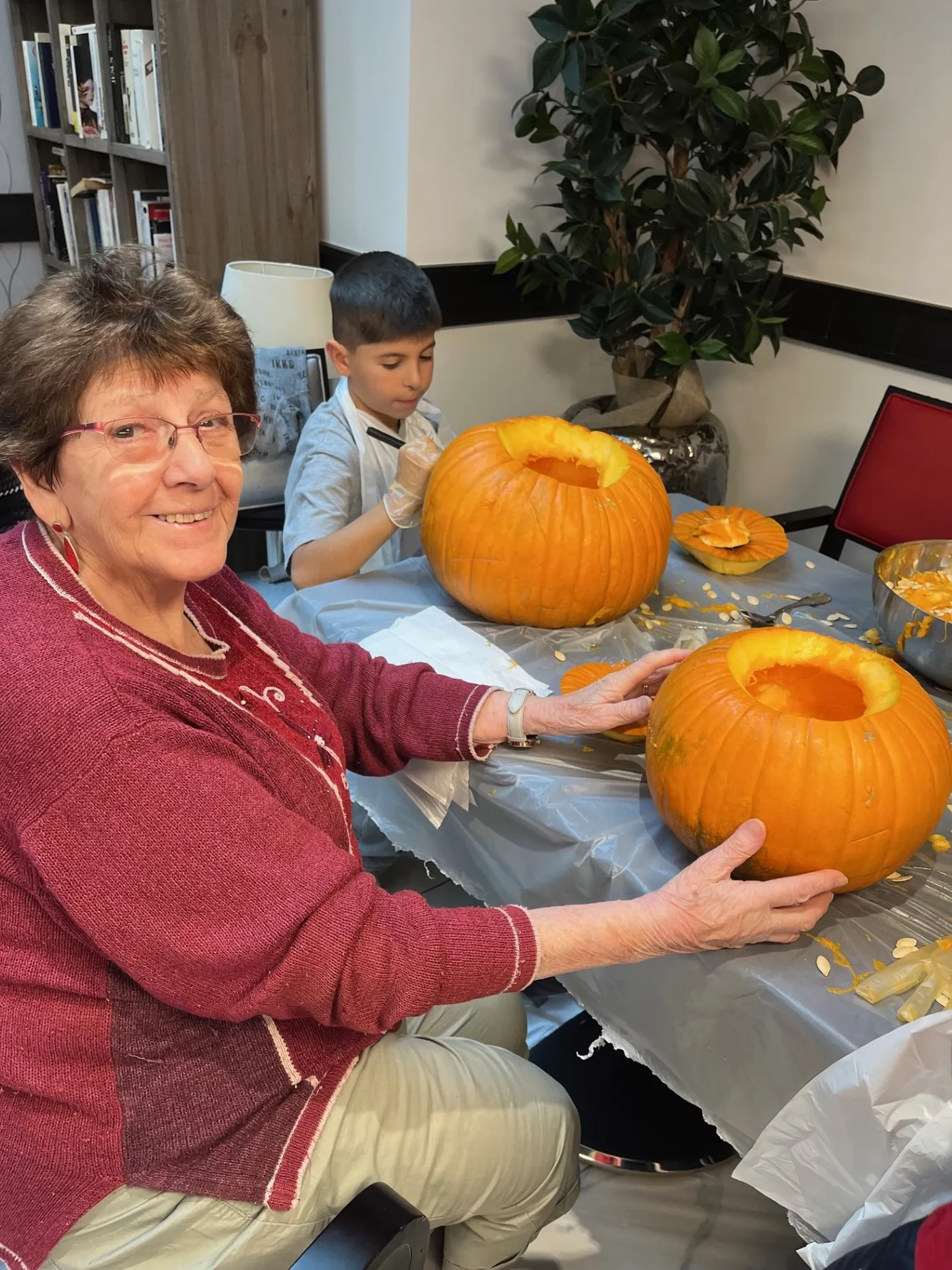 Une résidente et un enfant présentent les deux citrouilles qu'ils ont évidées