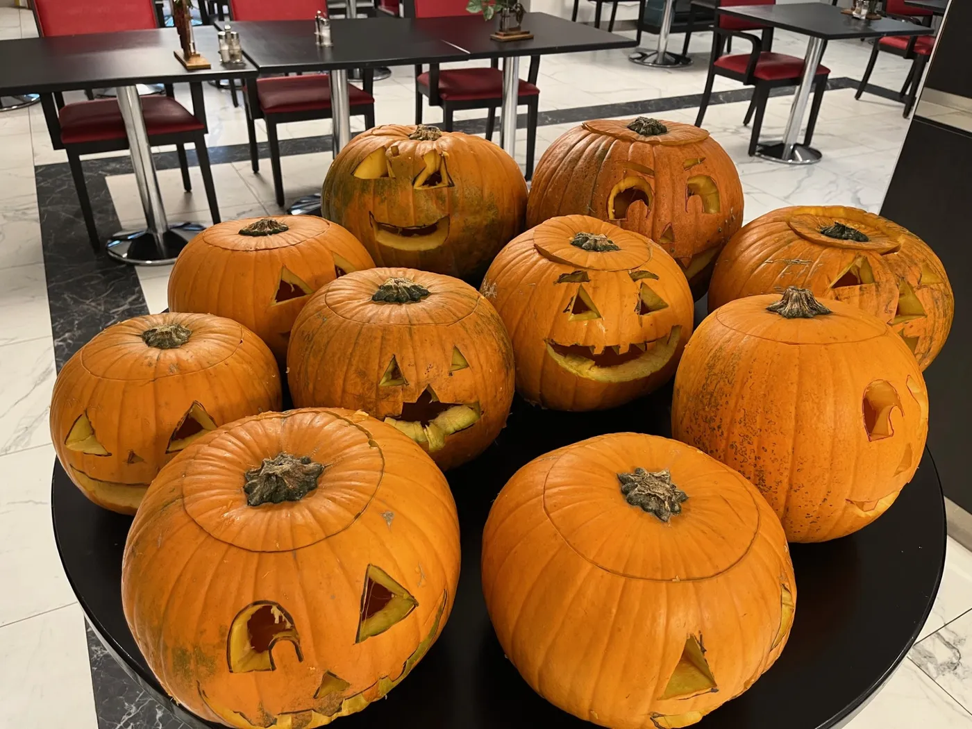 Une douzaine de citrouilles sculptées réunies sur une table de la salle à manger