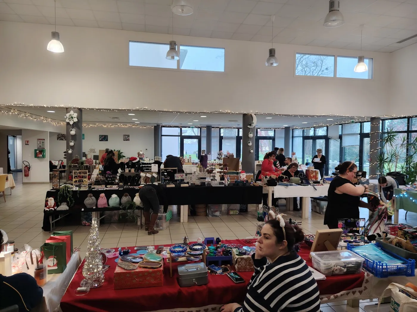 Vue large du marché, exposants et visiteurs entre les tables