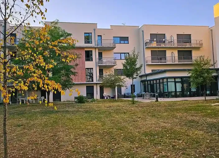 La résidence de Nevers et sa pelouse un jour d'automne, un arbre jaunissant au premier plan