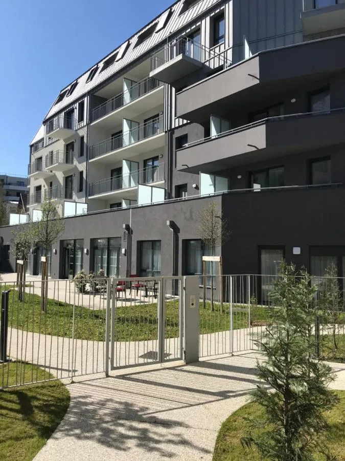 La façade noir et blanc de la résidence de Chambéry et l'allée de son jardin