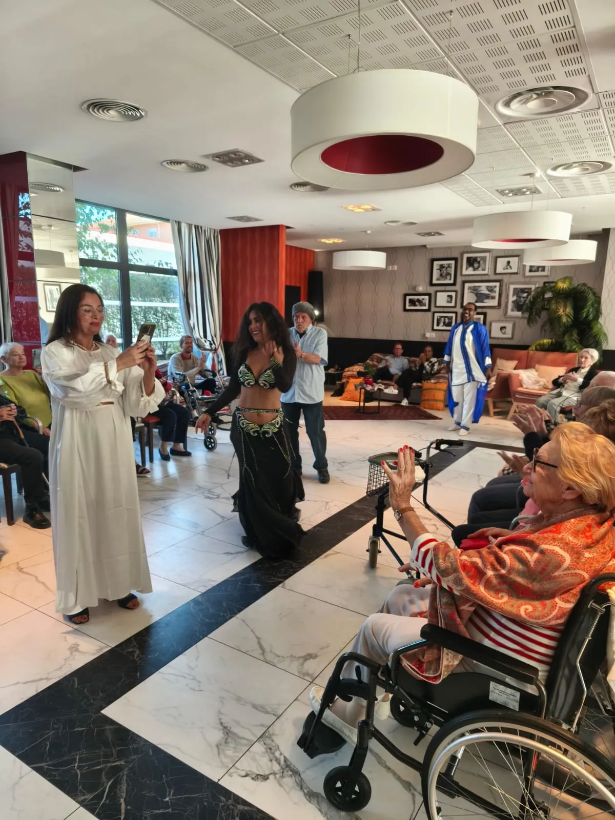 Une danseuse en robe blanche se produit devant les résidents assis