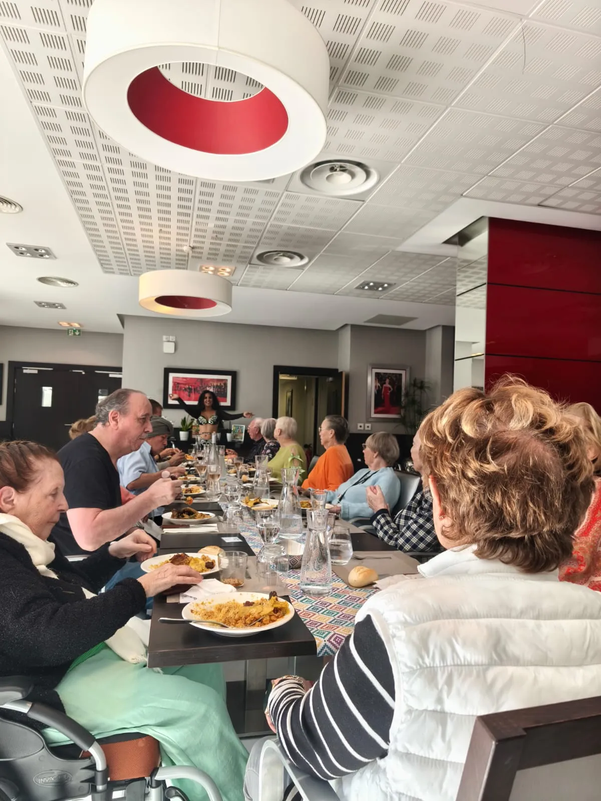 Des résidents déjeunent ensemble le long de la table de fête