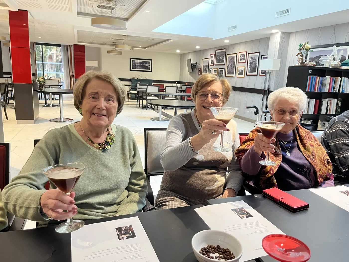 Trois résidentes lèvent leurs verres de cocktail vers l'objectif