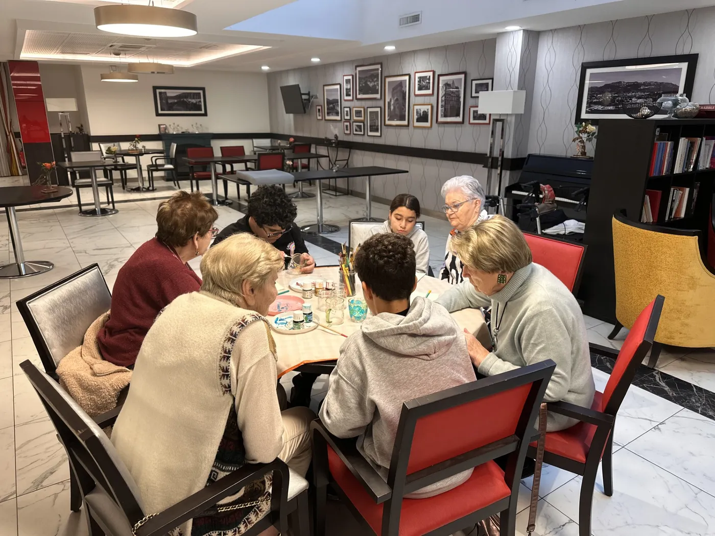 Résidents et enfants travaillent côte à côte à la table d'activités