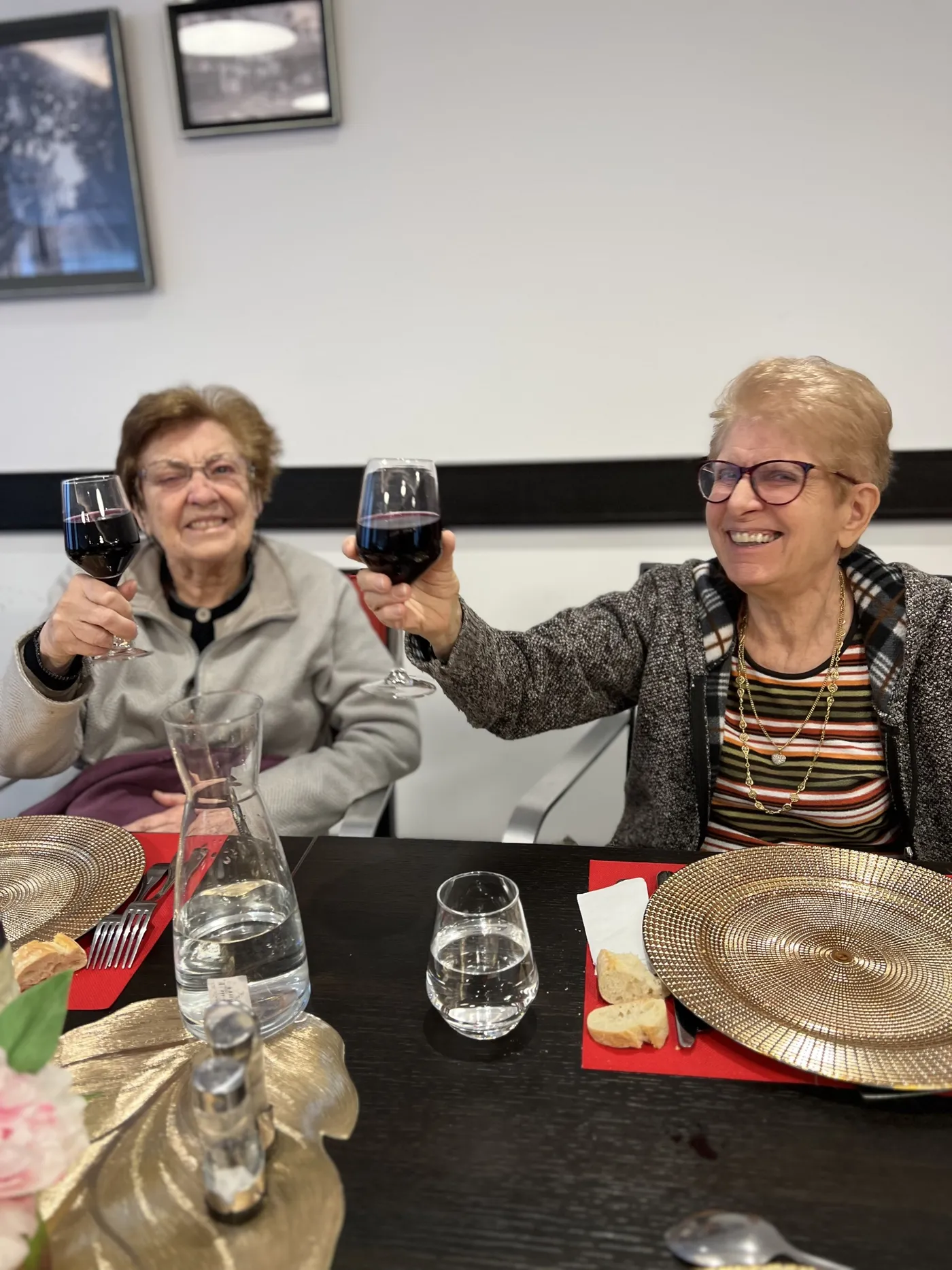 Deux résidentes brandissent leurs verres de vin bien haut en riant