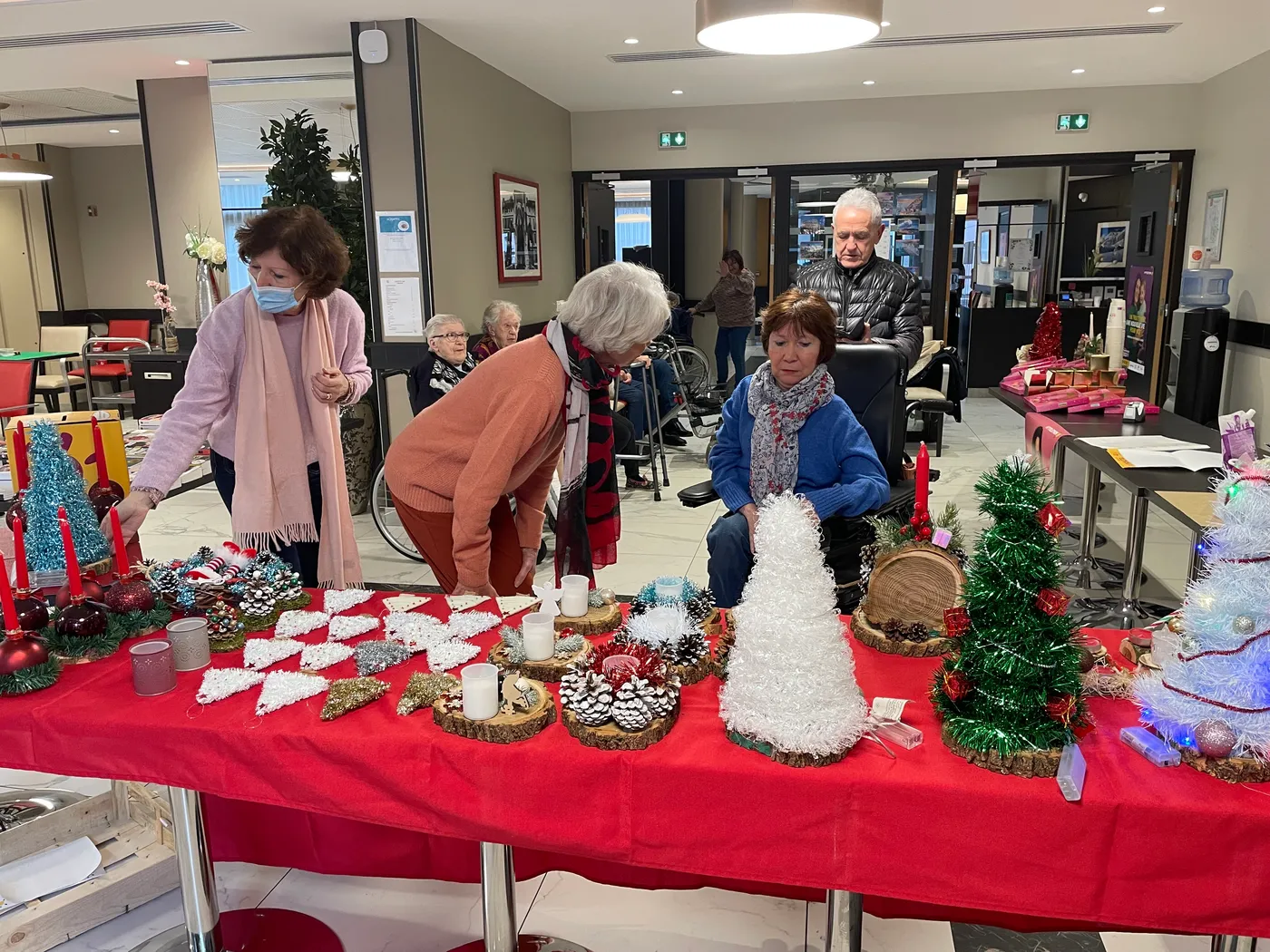 Le stand du Téléthon, sa nappe rouge couverte de décorations de Noël faites main