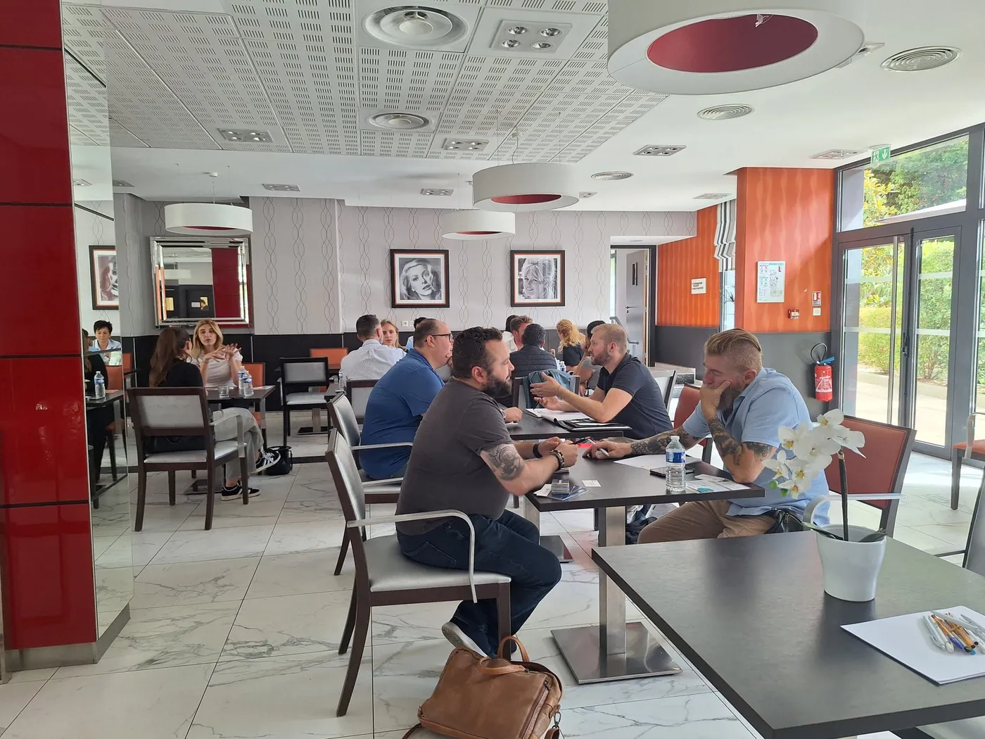 Des participants installés par deux ou trois aux tables pendant la session de mise en relation